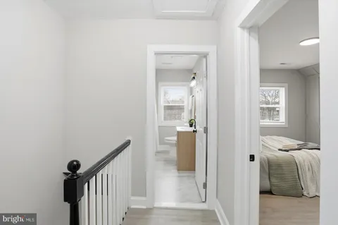 a view of a hallway with a livingroom and a bathroom with sink