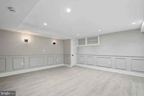 an empty room with wooden floor and white walls
