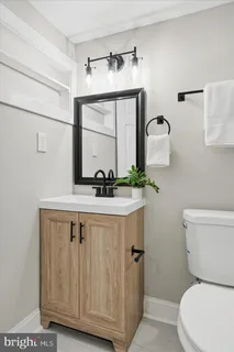 a bathroom with a toilet a sink and a mirror