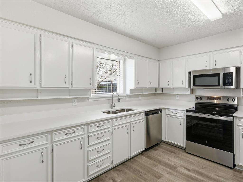 625 Reno Street Lewisville, TX 75077 - Photo 13 of 25 a kitchen with white cabinets appliances and a sink