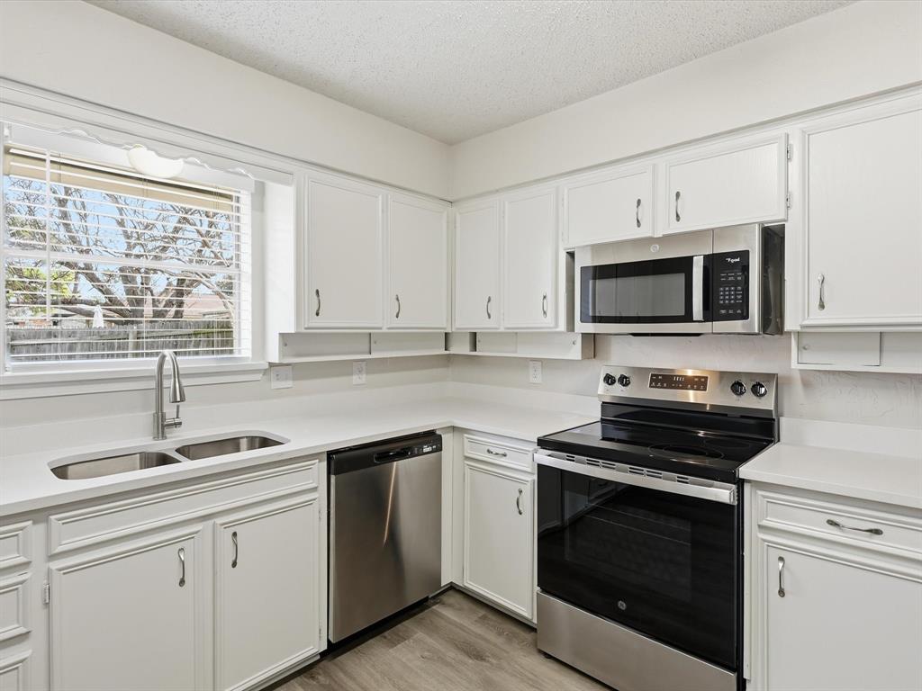 625 Reno Street Lewisville, TX 75077 - Photo 15 of 25 a kitchen with cabinets stainless steel appliances a sink and a window