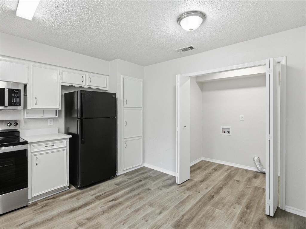 625 Reno Street Lewisville, TX 75077 - Photo 18 of 25 a kitchen with a refrigerator and a sink