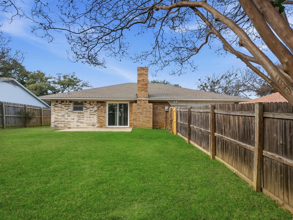 625 Reno Street Lewisville, TX 75077 - Photo 24 of 25 a view of a backyard with wooden fence and large trees