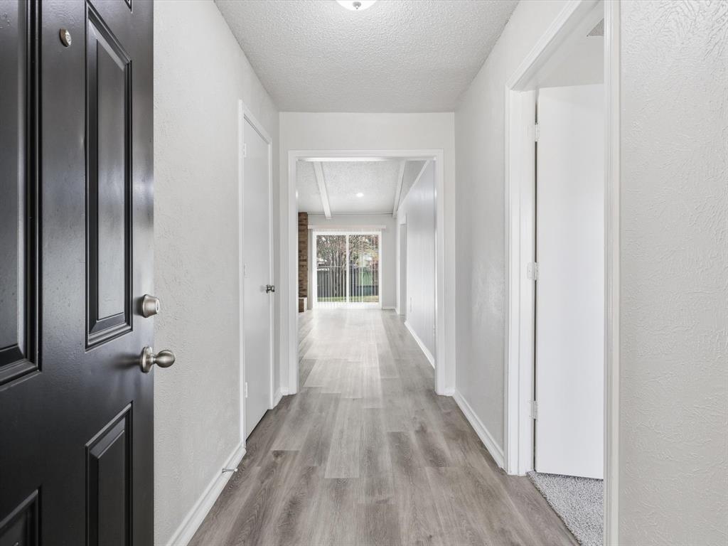 625 Reno Street Lewisville, TX 75077 - Photo 3 of 25 a view of a hallway with wooden floor and a bathroom
