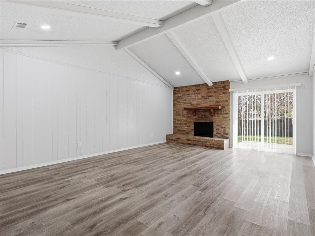 625 Reno Street Lewisville, TX 75077 - Photo 9 of 25 an empty room with wooden floor fireplace and windows