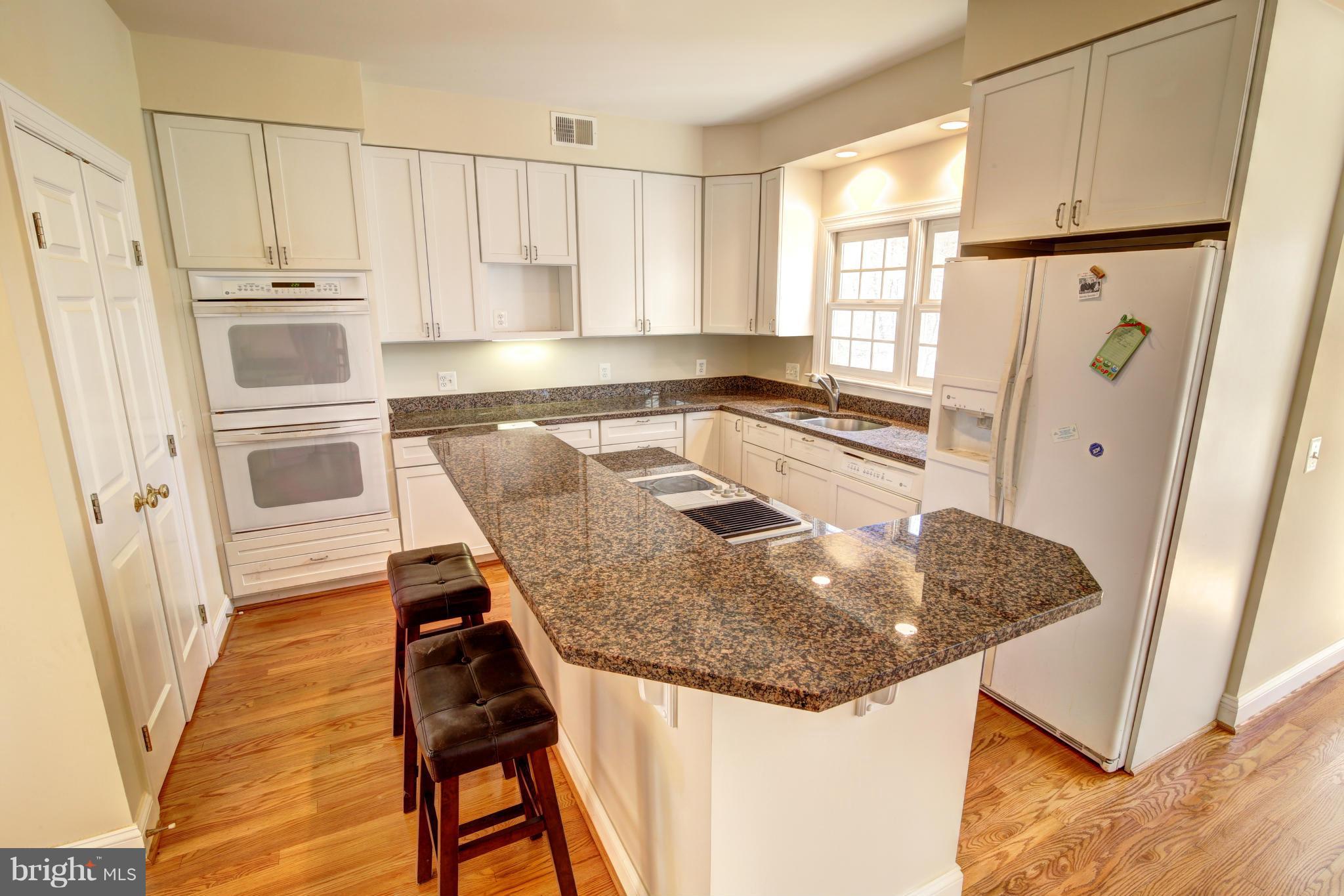 38990 Lime Kiln Road Leesburg, VA 20175 - Photo 7 of 30 a kitchen with stainless steel appliances granite countertop a refrigerator a stove and white cabinets with wooden floor