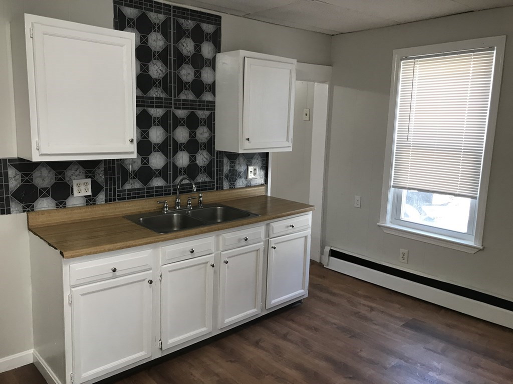 187 Mammoth Road Lowell, MA 01854 - Photo 2 of 8 a kitchen with a sink and cabinets