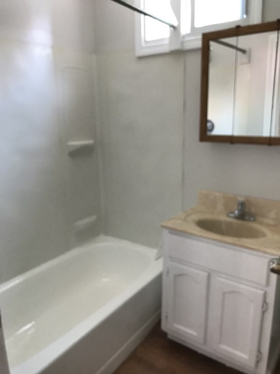 187 Mammoth Road Lowell, MA 01854 - Photo 5 of 8 a bathroom with a granite countertop sink a toilet and mirror
