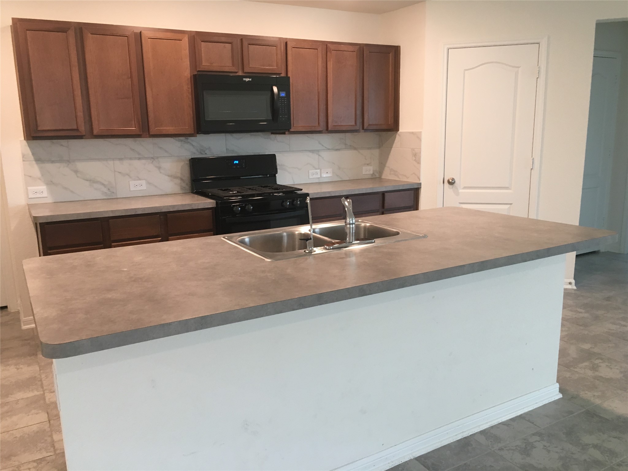 10429 Sherwin Pass Drive Rosharon, TX 77583 - Photo 4 of 11 a kitchen with granite countertop a sink a stove and a wooden cabinets