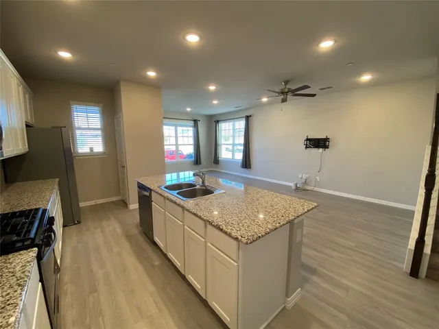 a kitchen with stainless steel appliances granite countertop a sink a stove top oven a counter space and cabinets