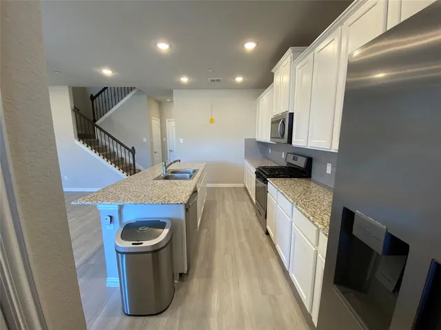 a kitchen with kitchen island granite countertop counter top space cabinets and stainless steel appliances