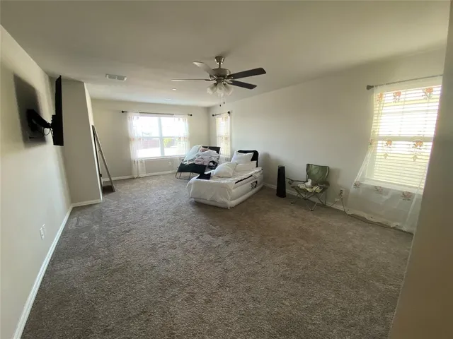 an empty room with a ceiling fan and a window