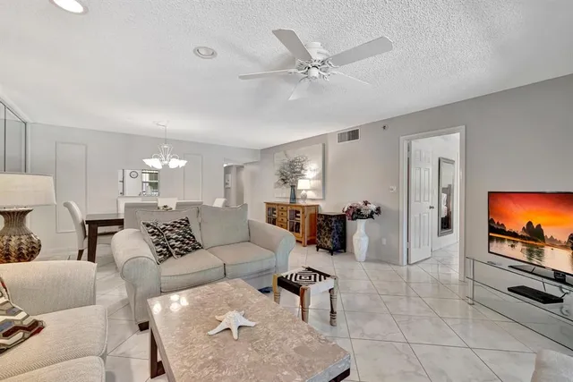 a dining room with furniture a large window and a chandelier