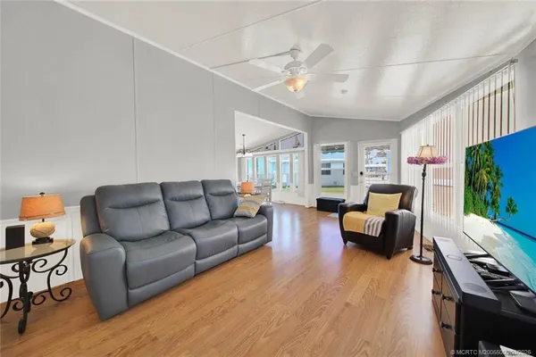 a living room with furniture flat screen tv and wooden floor