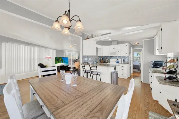 a kitchen view with stainless steel appliances refrigerator dining table and chairs