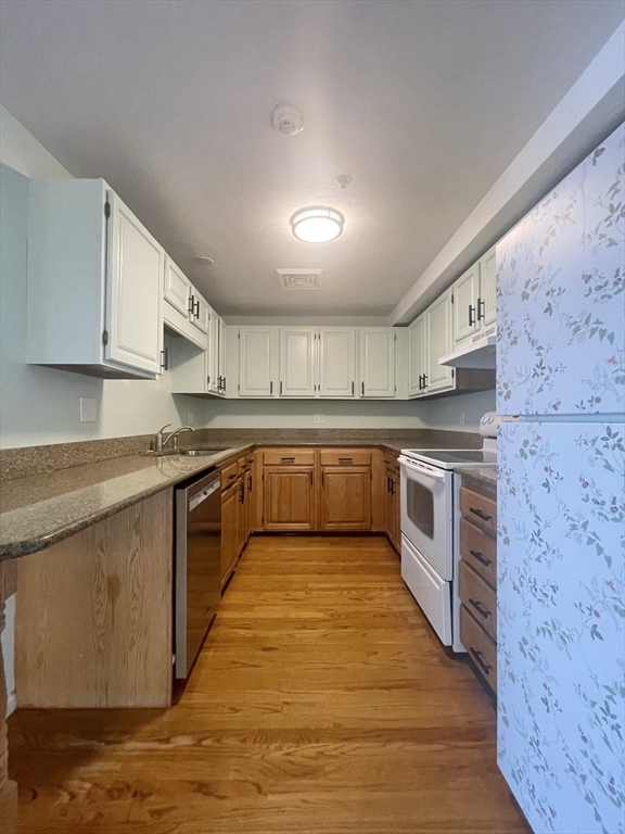 39 Parlin Street, Unit 404 Everett, MA 02149 - Photo 1 of 25 a large white kitchen with stainless steel appliances granite countertop a stove and a sink