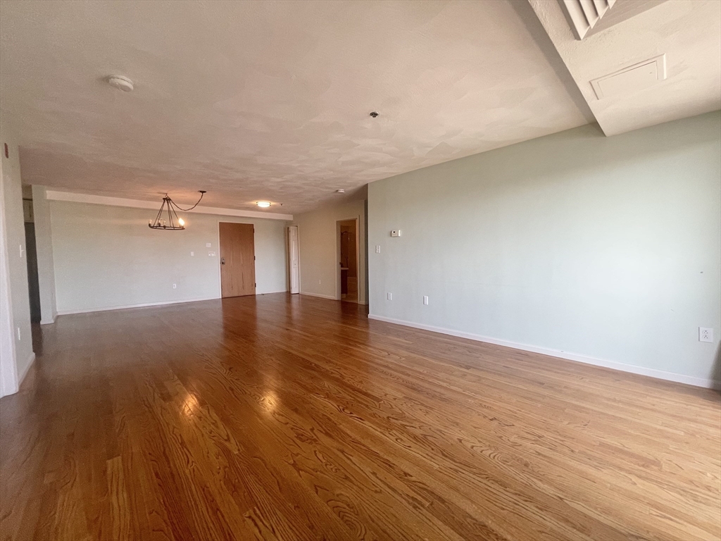 39 Parlin Street, Unit 404 Everett, MA 02149 - Photo 11 of 25 a view of empty room with wooden floor
