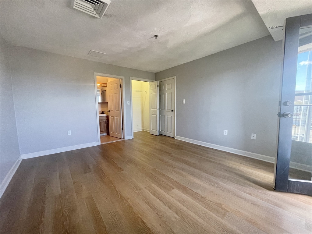 39 Parlin Street, Unit 404 Everett, MA 02149 - Photo 12 of 25 a view of an empty room with wooden floor and a window