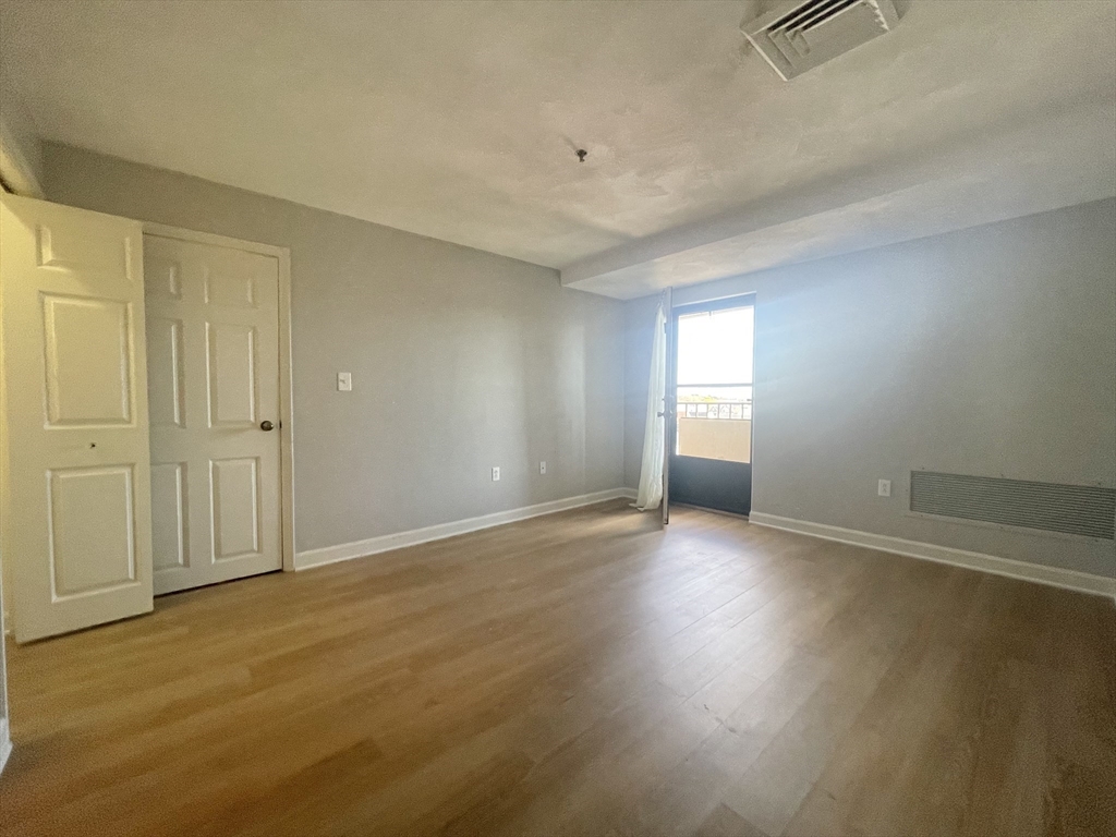 39 Parlin Street, Unit 404 Everett, MA 02149 - Photo 13 of 25 an empty room with wooden floor and windows