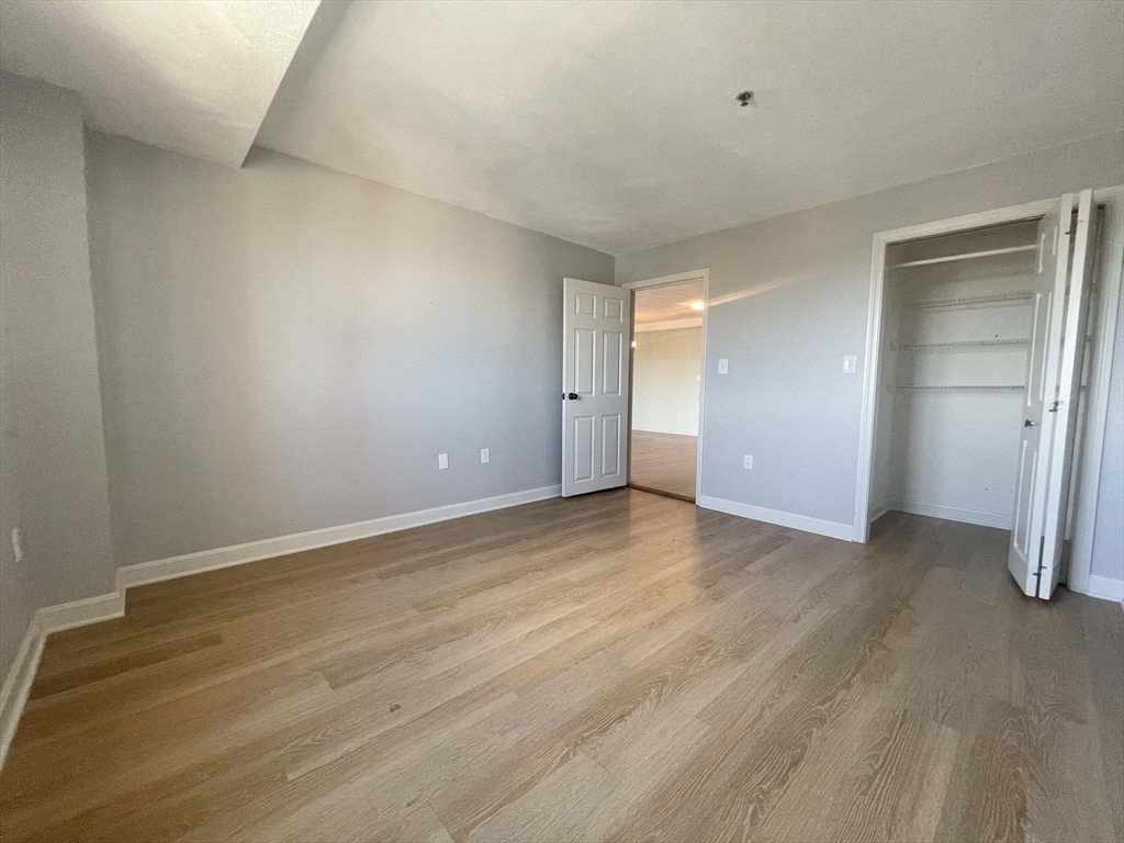 39 Parlin Street, Unit 404 Everett, MA 02149 - Photo 15 of 25 a view of an empty room with wooden floor