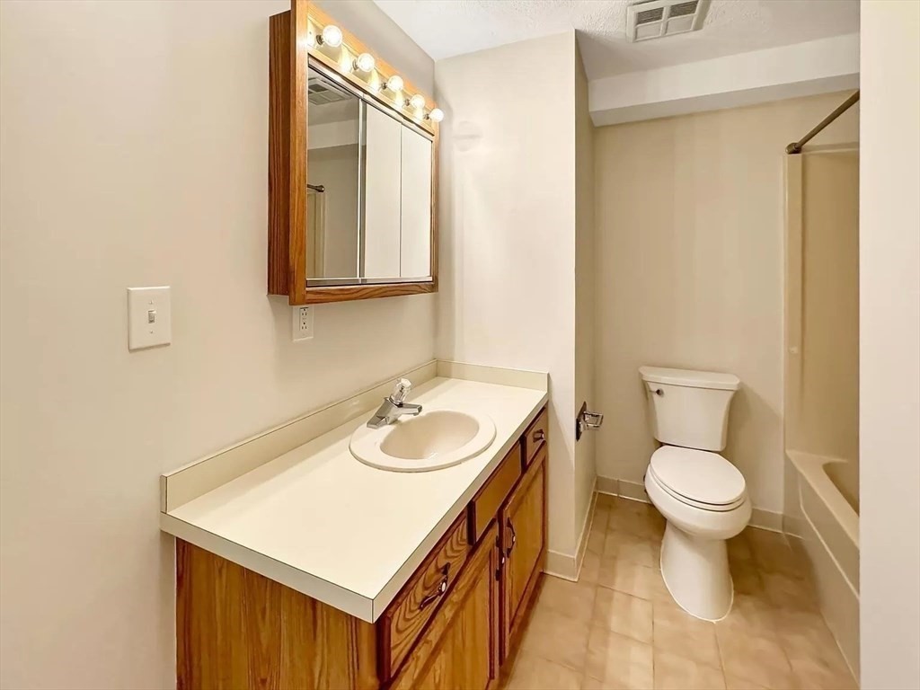 39 Parlin Street, Unit 404 Everett, MA 02149 - Photo 17 of 25 a bathroom with a sink a toilet and a mirror