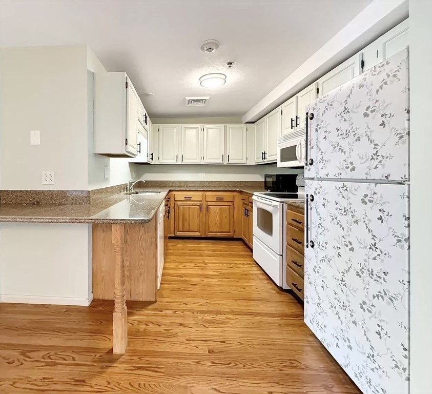 39 Parlin Street, Unit 404 Everett, MA 02149 - Photo 5 of 25 a kitchen with stainless steel appliances granite countertop a stove top oven a sink and a refrigerator