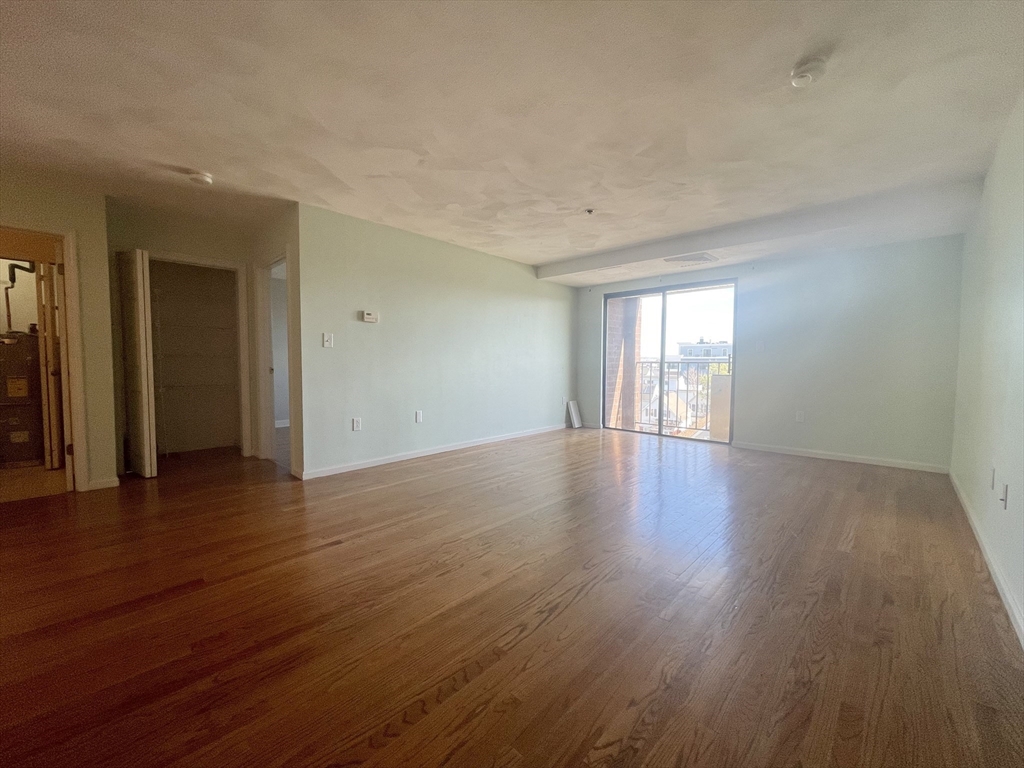 39 Parlin Street, Unit 404 Everett, MA 02149 - Photo 8 of 25 a view of an empty room with wooden floor and a window