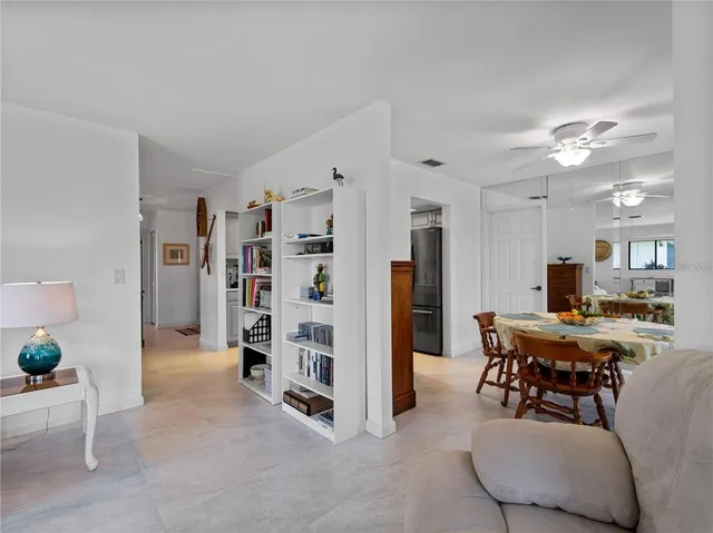 a living room with furniture a flat screen tv and a floor to ceiling window