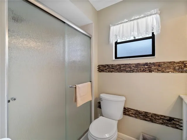 a bathroom with a granite countertop toilet sink and mirror