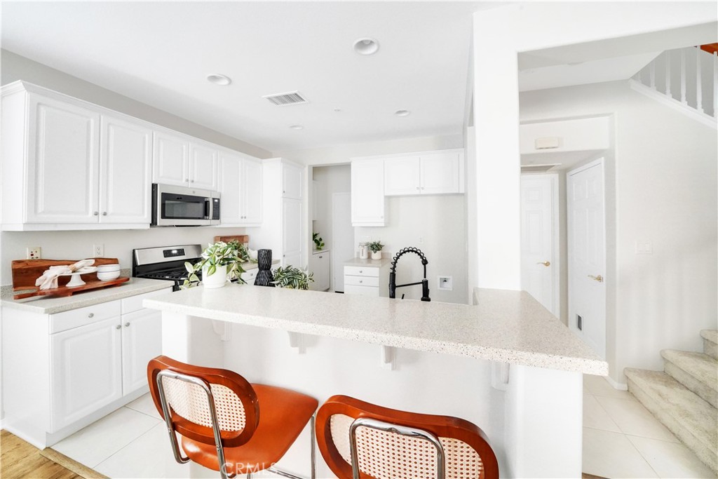 6 Chadron Circle Ladera Ranch, CA 92694 - Photo 11 of 45 a kitchen with stainless steel appliances a sink a stove a refrigerator cabinets and a dining table