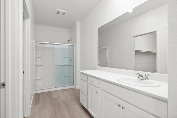 a bathroom with a shower sink and mirror