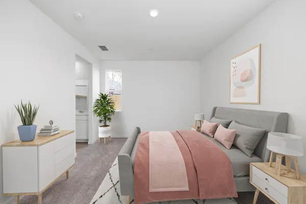 a bedroom with a bed and a potted plant