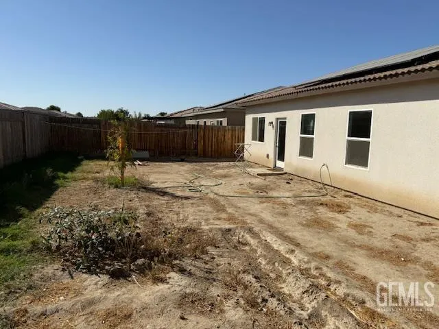 a backyard of a house with table and chairs