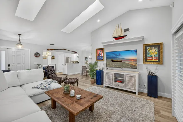 a dining room with wooden floor a chandelier a wooden table and chairs
