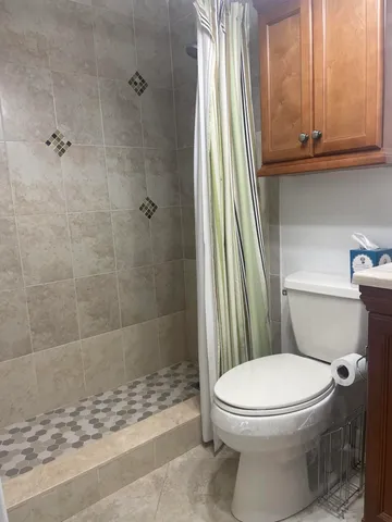 a bathroom with a granite countertop toilet sink and mirror