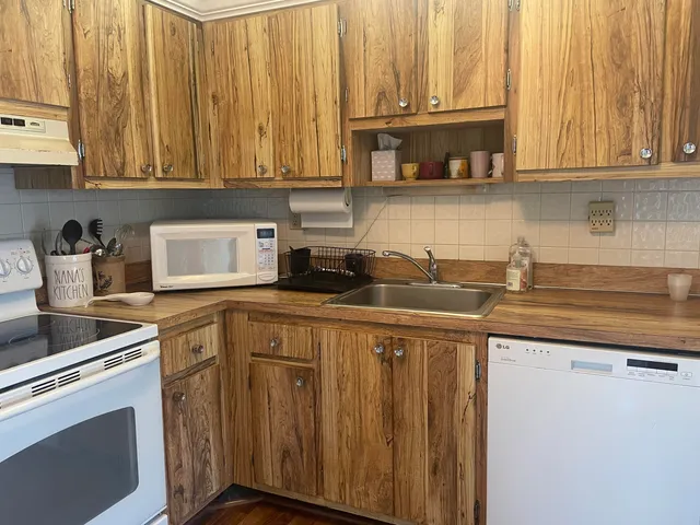 a kitchen with stainless steel appliances granite countertop a sink a stove a microwave and cabinets