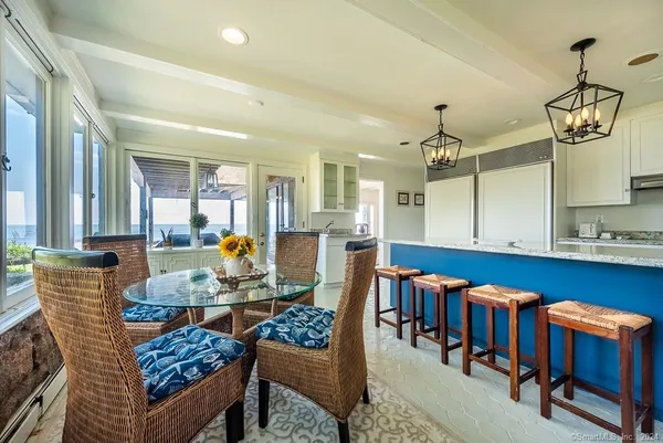 a kitchen with stainless steel appliances a table chairs and cabinets