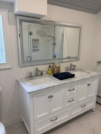 a bathroom with a double vanity sink and mirror