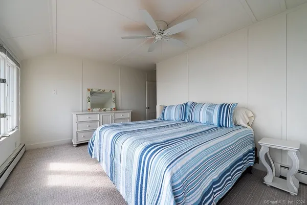 a bedroom with a bed and a painting on the wall