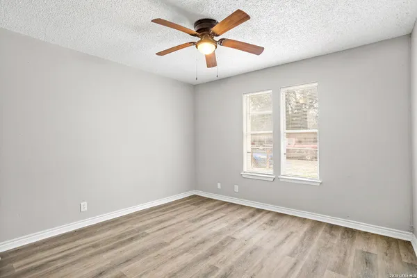 an empty room with window and a ceiling fan