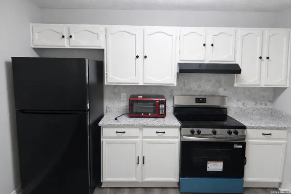 a kitchen with stainless steel appliances white cabinets and a stove