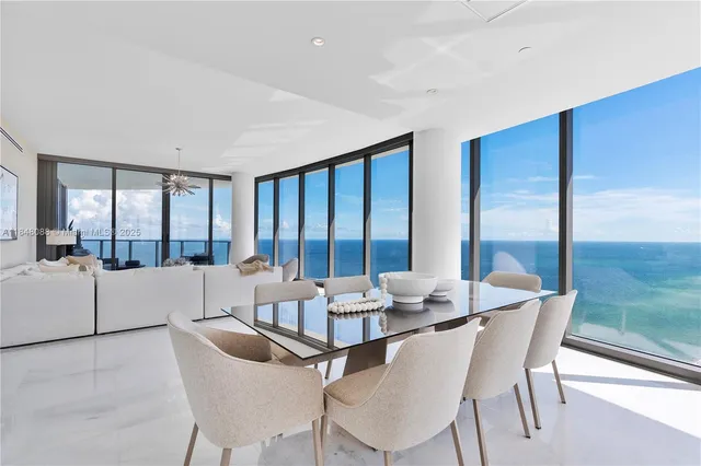 a dining room with furniture and a large window