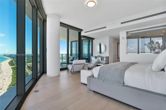 a bedroom with bed and large windows