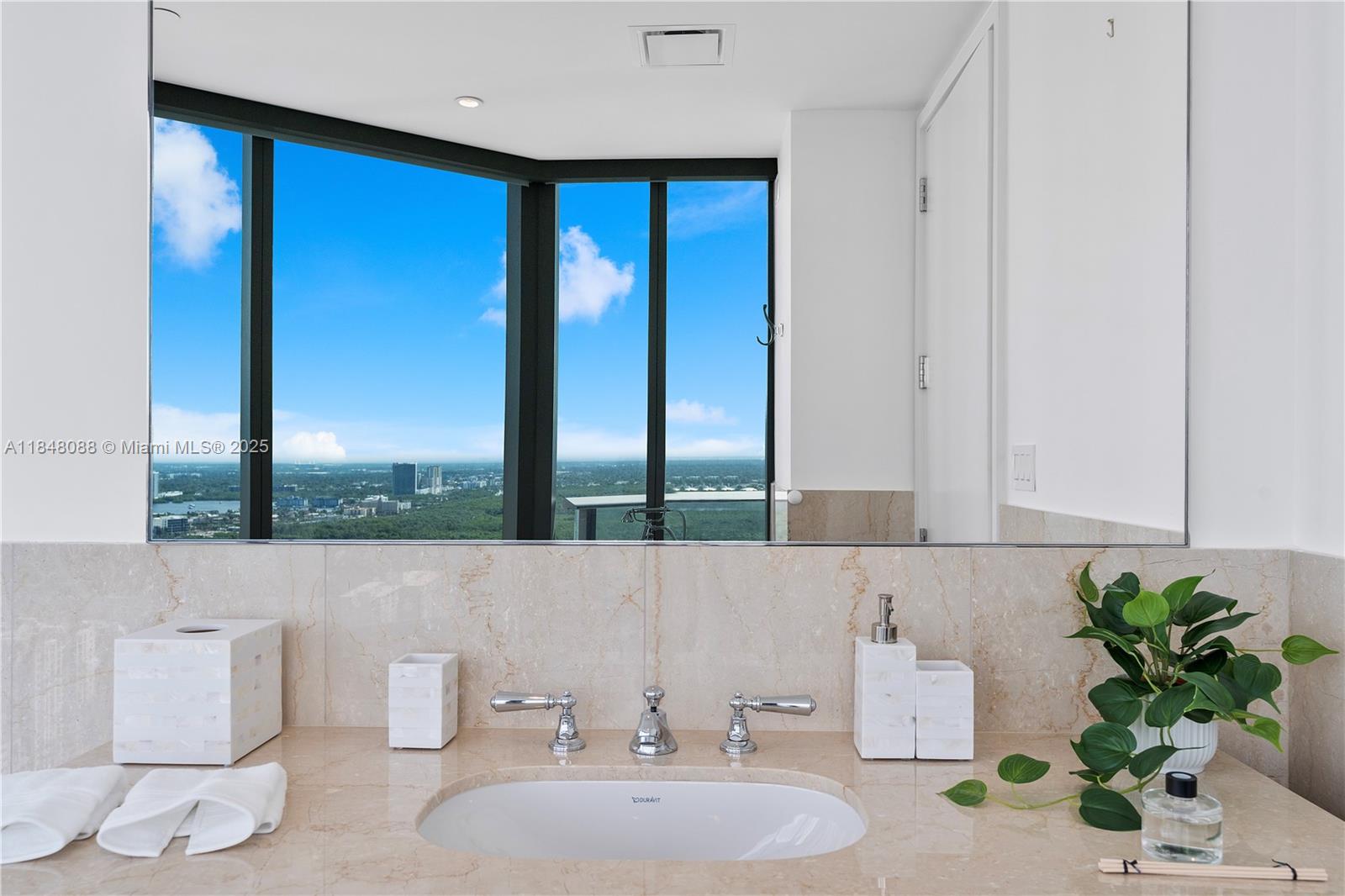 15701 Collins Avenue, Unit 3605 Sunny Isles Beach, FL 33160 - Photo 24 of 46 a bathroom with a sink and a mirror