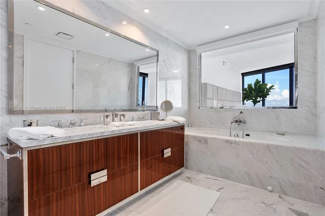a bathroom with a tub double sink and mirror