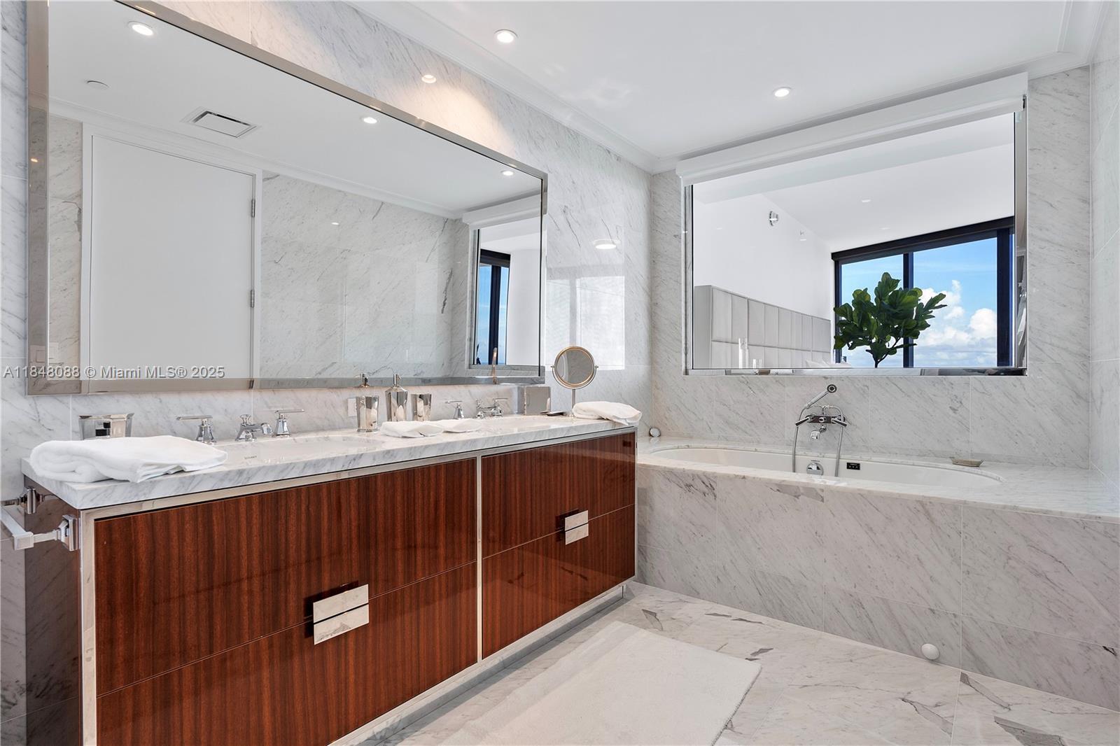 15701 Collins Avenue, Unit 3605 Sunny Isles Beach, FL 33160 - Photo 25 of 46 a bathroom with a tub double sink and mirror