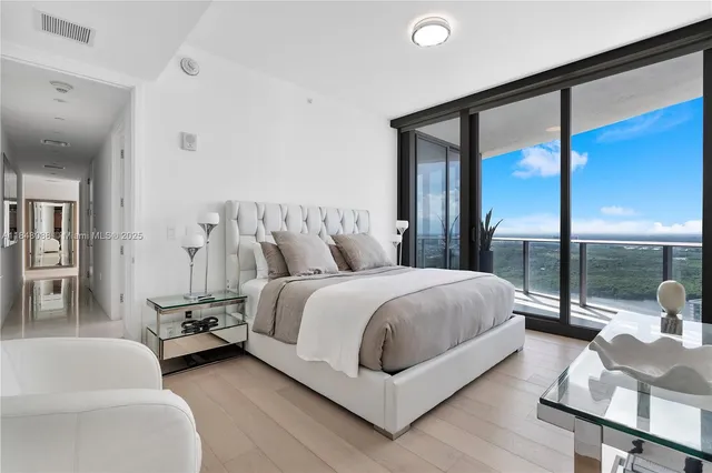 a bedroom with a bed and large glass window
