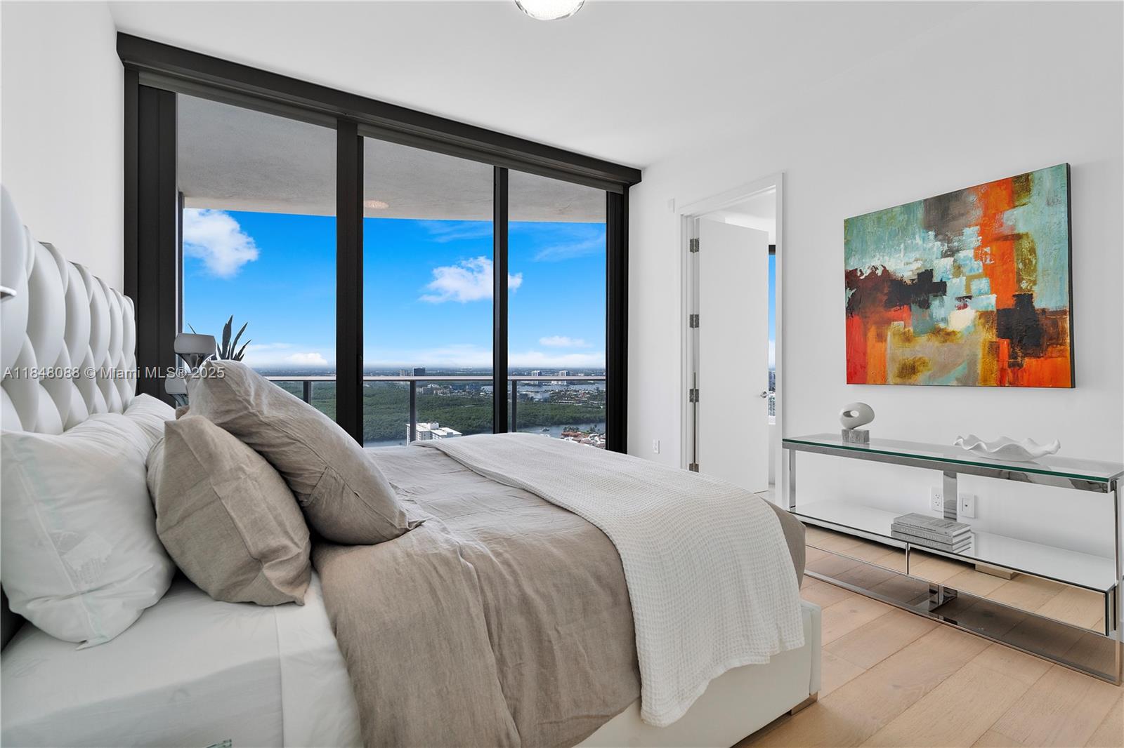 15701 Collins Avenue, Unit 3605 Sunny Isles Beach, FL 33160 - Photo 30 of 46 a bedroom with a large bed and a painting on the wall