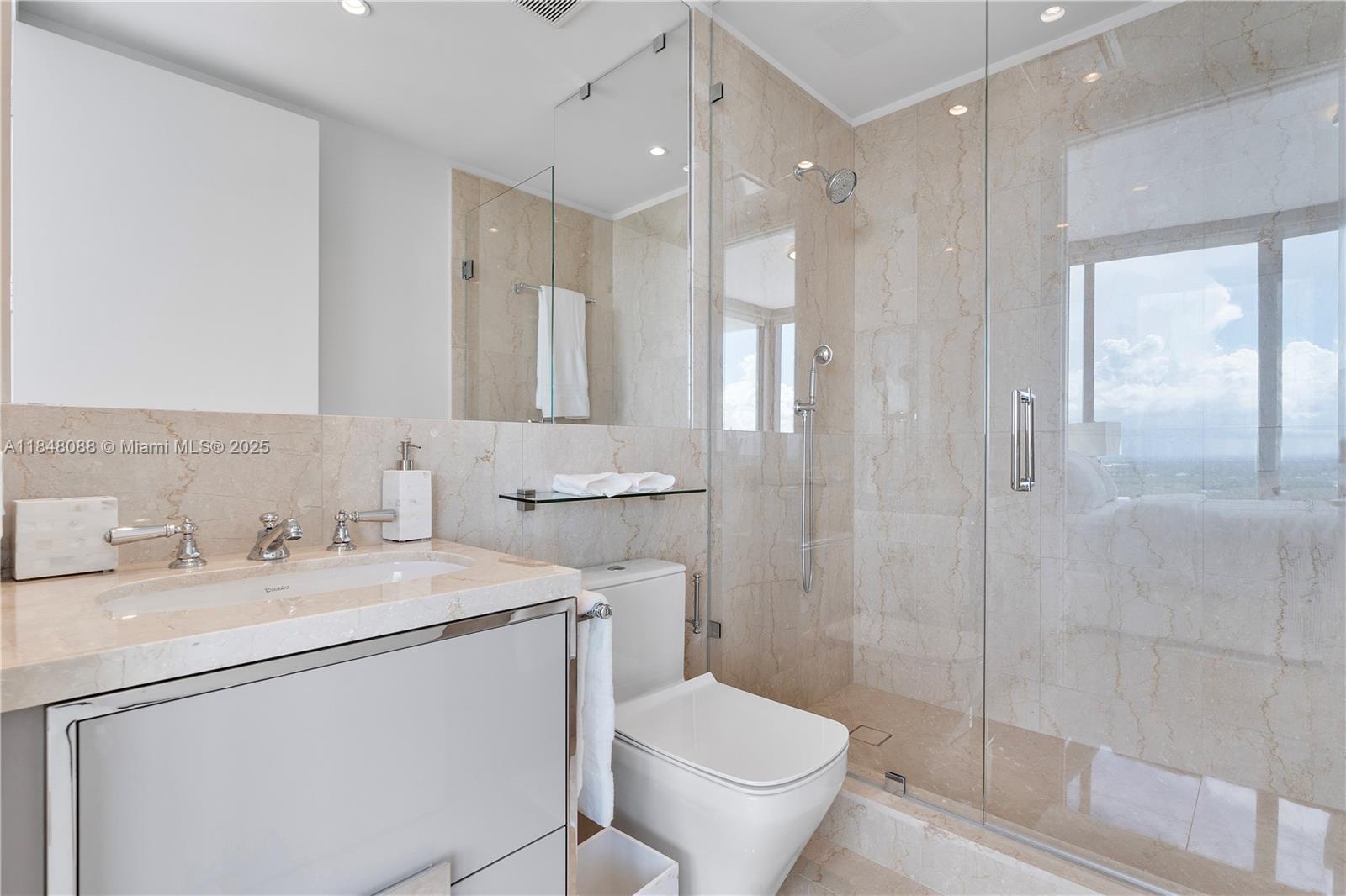 15701 Collins Avenue, Unit 3605 Sunny Isles Beach, FL 33160 - Photo 32 of 46 a bathroom with a sink toilet vanity and shower