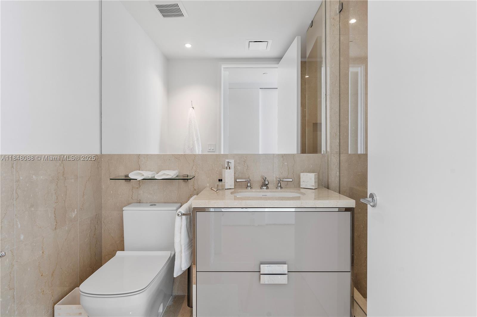 15701 Collins Avenue, Unit 3605 Sunny Isles Beach, FL 33160 - Photo 34 of 46 a view of bathroom with a sink toilet and mirror